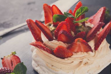 Anna Pavlova pasta siyah arka plan üzerine çilek ile