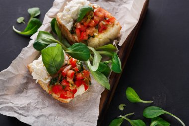 Bruschetta peynir ve siyah arka plan üzerine sebze ile
