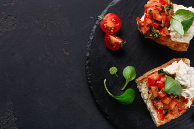 Bruschetta peynir ve siyah arka plan üzerine sebze ile