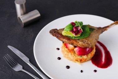 Restoran yemekleri. Ördek confit siyah arka plan üzerine sebzeli
