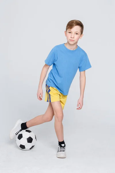 Boy in casual with soccer ball at white studio background — Stock Photo, Image