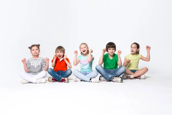 Glückliche Kinder, die im Studio auf dem Boden liegen, Kopierraum — Stockfoto