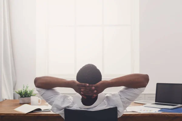 Relajado hombre de negocios negro con portátil en la oficina blanca moderna — Foto de Stock