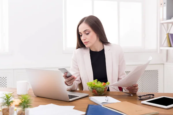 Giovane donna d'affari mangiare insalata in ufficio — Foto Stock