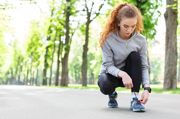 Mujer atando cordones zapatos antes de correr — Foto de Stock