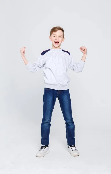 Portrait of cheerful boy celebrating victory at studio background — Stock Photo, Image