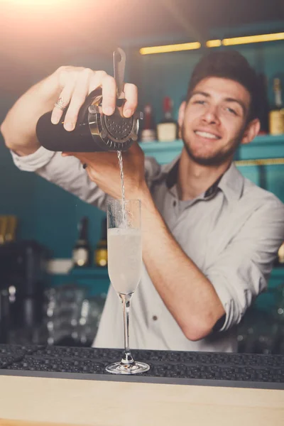 Barman tânăr turnând băutură cocktail în sticlă — Fotografie, imagine de stoc