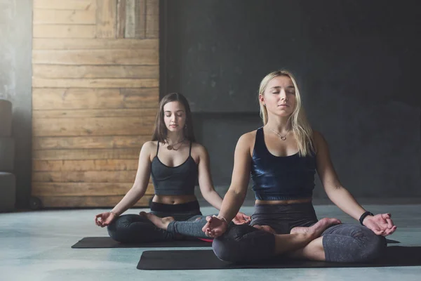 Jovens mulheres na aula de ioga, relaxar pose meditação — Fotografia de Stock
