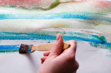 Elinde fırça. Sanatçı suluboya resim oluşturma