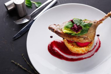 Restoran yemekleri. Ördek confit siyah arka plan üzerine sebzeli