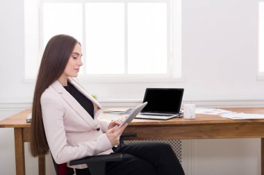 İş kadını ofiste belge okuyor.