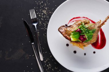 Restoran yemekleri. Ördek confit siyah arka plan üzerine sebzeli