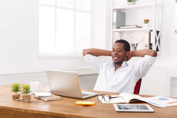 Jonge ontspannen zakenman met laptop in moderne witte kantoor — Stockfoto