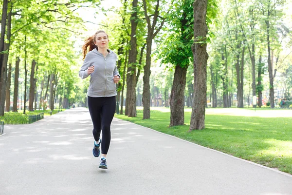 Mujer joven corriendo en el parque verde, espacio de copia —  Fotos de Stock