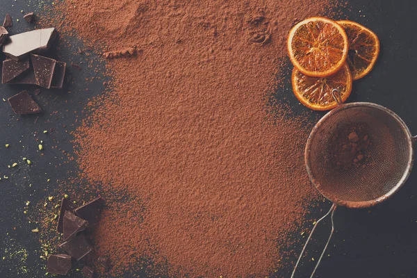 Siyah arduvaz arka plan üzerinde bir elek içinde kakao tozu