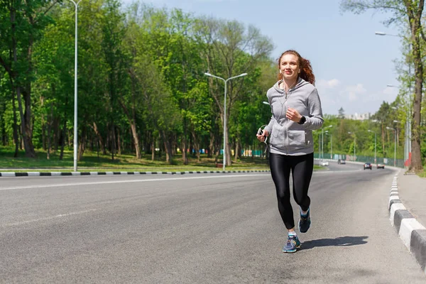 Mujer joven corriendo por la carretera, espacio de copia —  Fotos de Stock