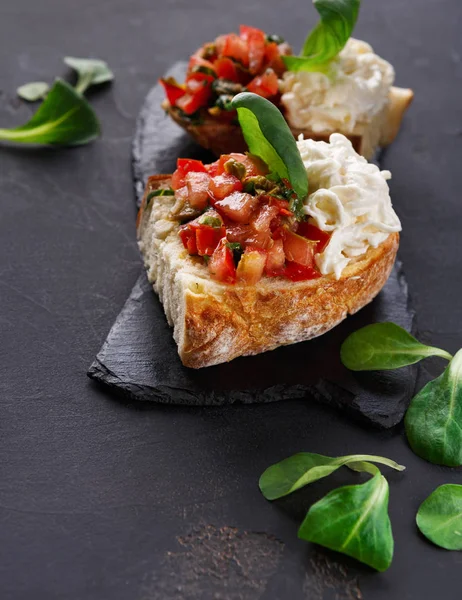 Bruschetta peynir ve siyah arka plan üzerine sebze ile — Stok fotoğraf