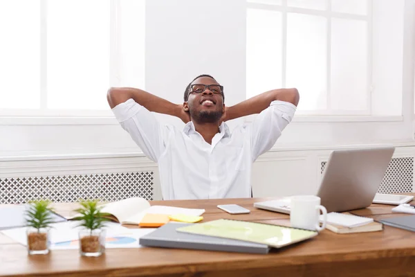 Relajado hombre de negocios negro con portátil en la oficina blanca moderna —  Fotos de Stock