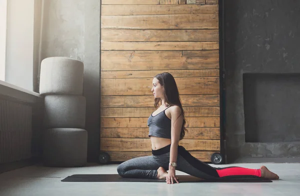 Giovane donna in classe di yoga che si estende testa al ginocchio posa — Foto Stock