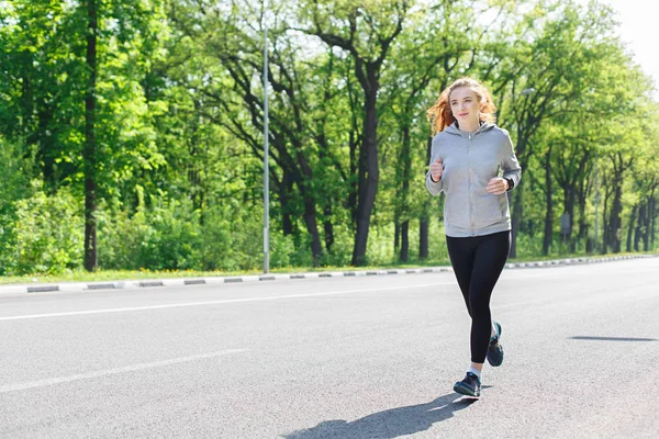 Mujer joven corriendo en la carretera, espacio para copiar —  Fotos de Stock