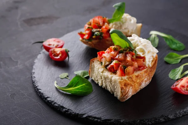 Bruschetta peynir ve siyah arka plan üzerine sebze ile — Stok fotoğraf