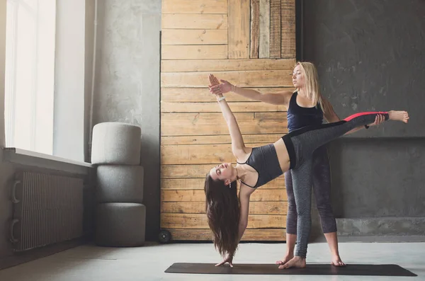 Femme en planche latérale pose avec entraîneur au cours de yoga — Photo