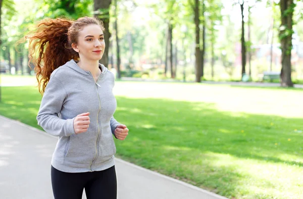 Mujer joven corriendo en el parque verde, espacio de copia —  Fotos de Stock