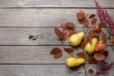 Ahşap arka plan üzerinde sonbahar natürmort ile armut ve kuru yaprakları