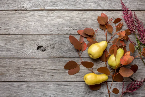 Ahşap arka plan üzerinde sonbahar natürmort ile armut ve kuru yaprakları