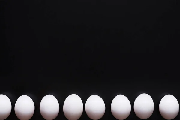 黒の背景に分離された白い卵 — ストック写真