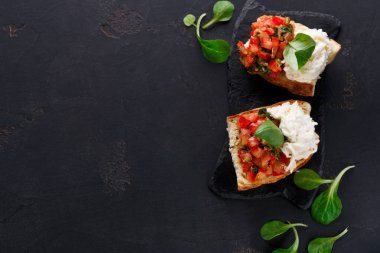 Bruschetta peynir ve siyah arka plan üzerine sebze ile