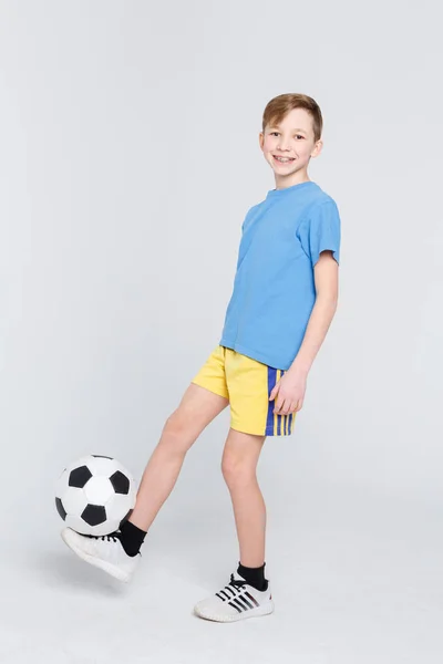 Niño en casual con pelota de fútbol en fondo blanco estudio — Foto de Stock