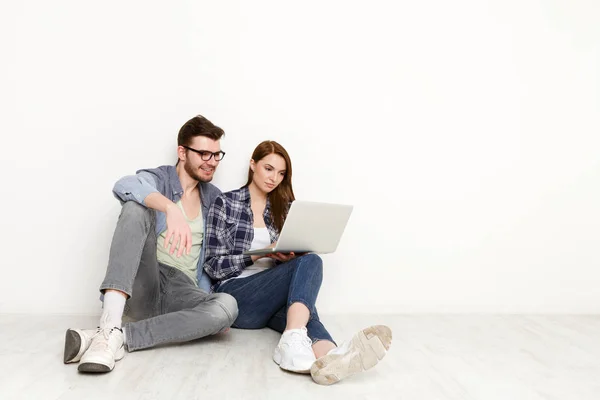 Casual pareja de compras en línea con el ordenador portátil, toma de estudio —  Fotos de Stock