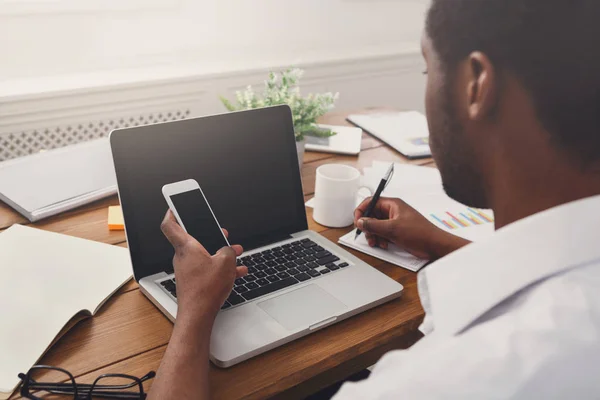 Afro-Amerikaanse zakenman op kantoor met mobiel en laptop — Stockfoto