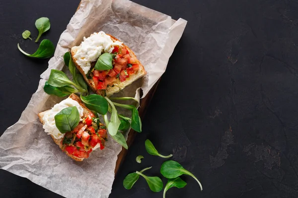 Bruschetta peynir ve siyah arka plan üzerine sebze ile