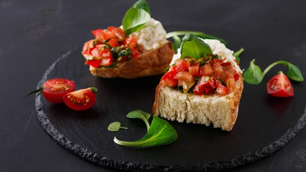 Bruschetta peynir ve siyah arka plan üzerine sebze ile — Stok fotoğraf