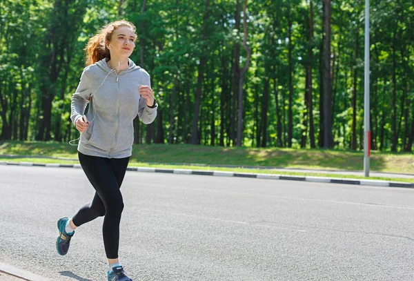 Mujer joven corriendo por la carretera, espacio de copia — Foto de Stock