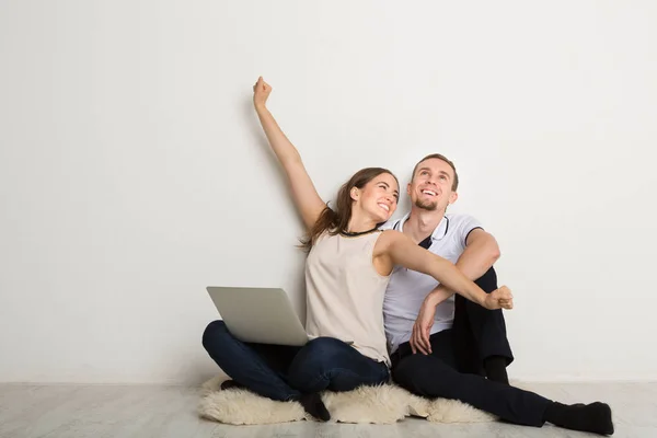 Pareja alegre usando el ordenador portátil en casa, espacio para copiar — Foto de Stock