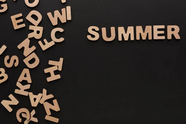 Slovo léto s hromadou dřevěných písmen — Stock fotografie