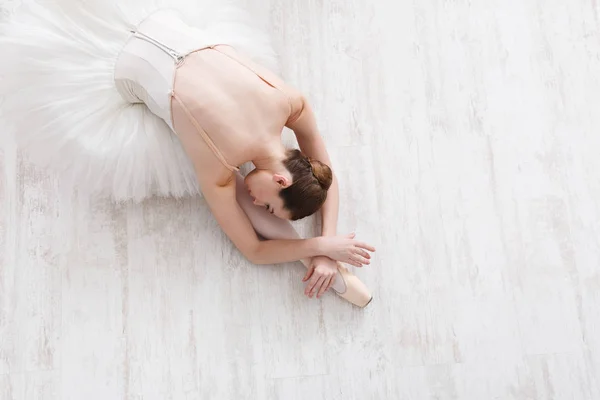Graceful ballerina stretching, ballet background