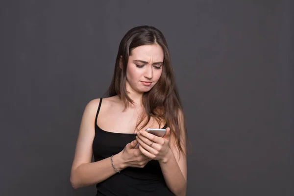 Unhappy young woman using smartphone portrait — Stock Photo, Image