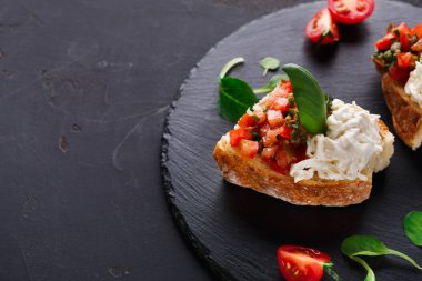 Bruschetta peynir ve siyah arka plan üzerine sebze ile