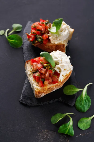 Bruschetta peynir ve siyah arka plan üzerine sebze ile — Stok fotoğraf