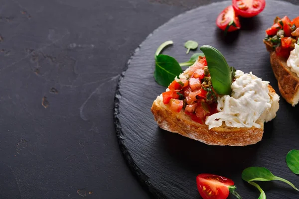 Bruschetta peynir ve siyah arka plan üzerine sebze ile