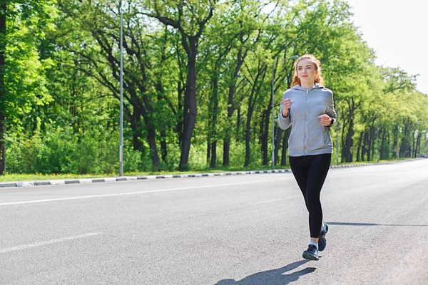 Mujer joven corriendo por la carretera, espacio de copia —  Fotos de Stock