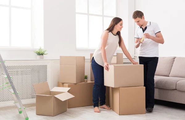 Casal jovem desempacotando caixas móveis — Fotografia de Stock
