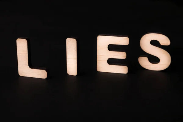 Palavra mentiras sobre fundo preto — Fotografia de Stock