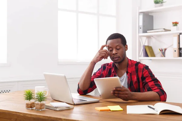 Ernstige jonge zwarte gelukkig zakenman in kantoor, werken met een laptop — Stockfoto