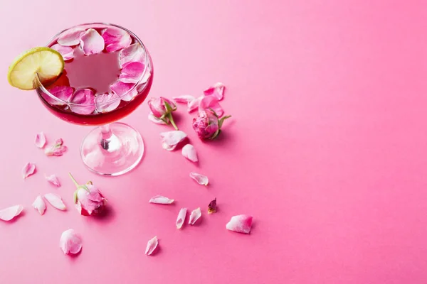 ピンクの背景にシャンパン グラスでバラのカクテル — ストック写真