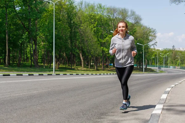 Mujer joven corriendo por la carretera, espacio de copia —  Fotos de Stock